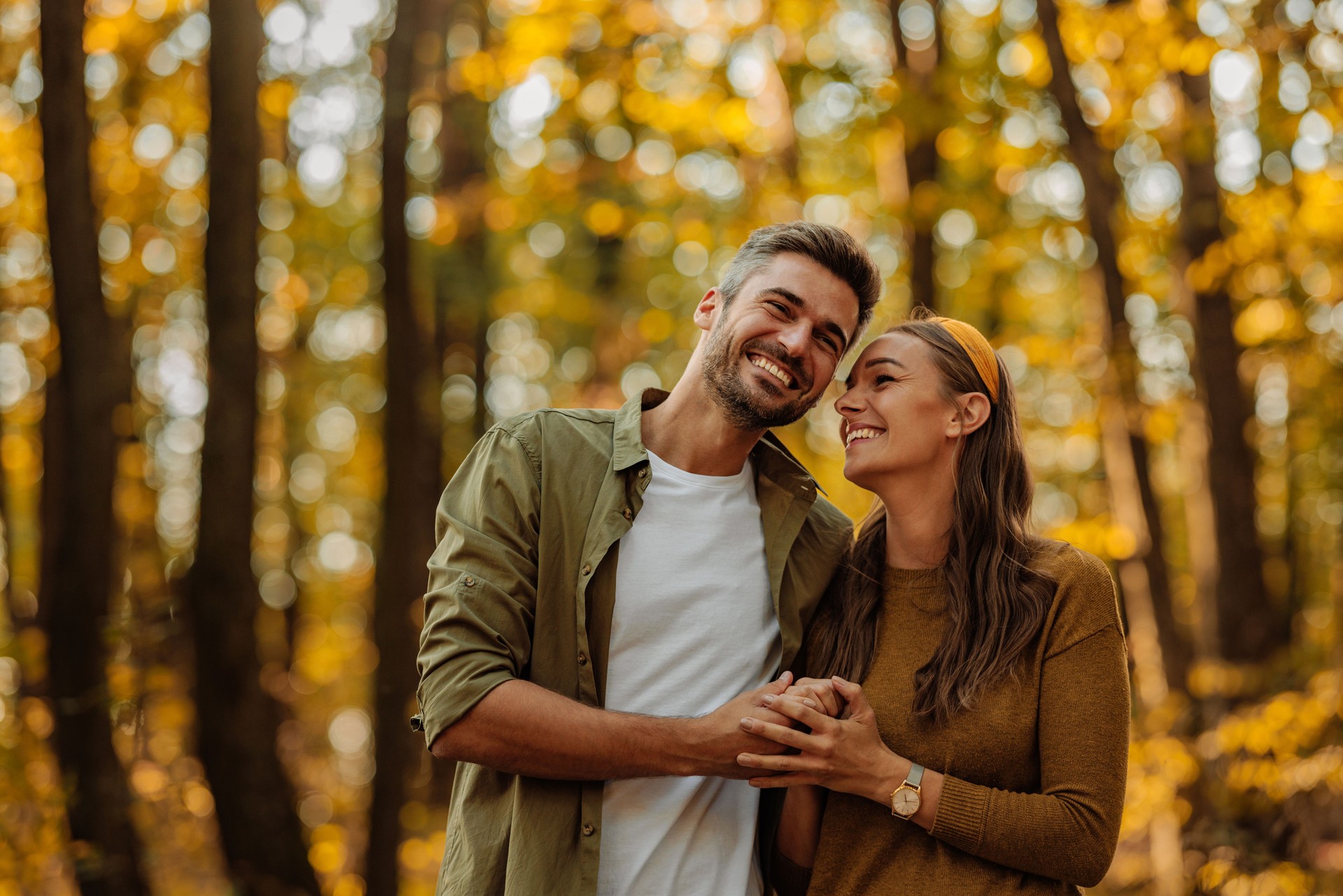 Happy couple in love hugging and walking in the forest