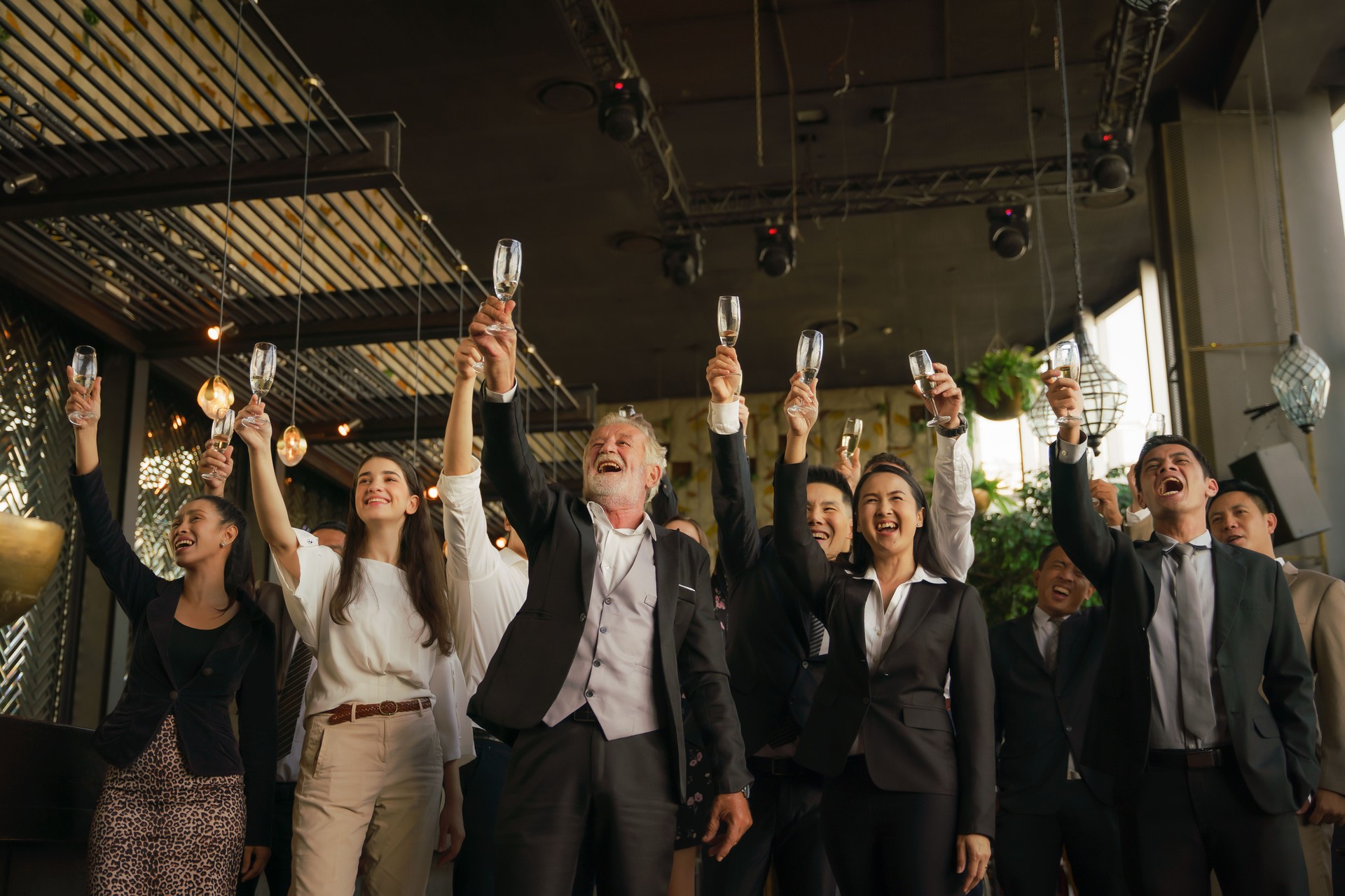 corporate businesspeople having business party toasting glasses of wine or champagne together to celebrate friendship and teamwork in special event such as corporate aniversary